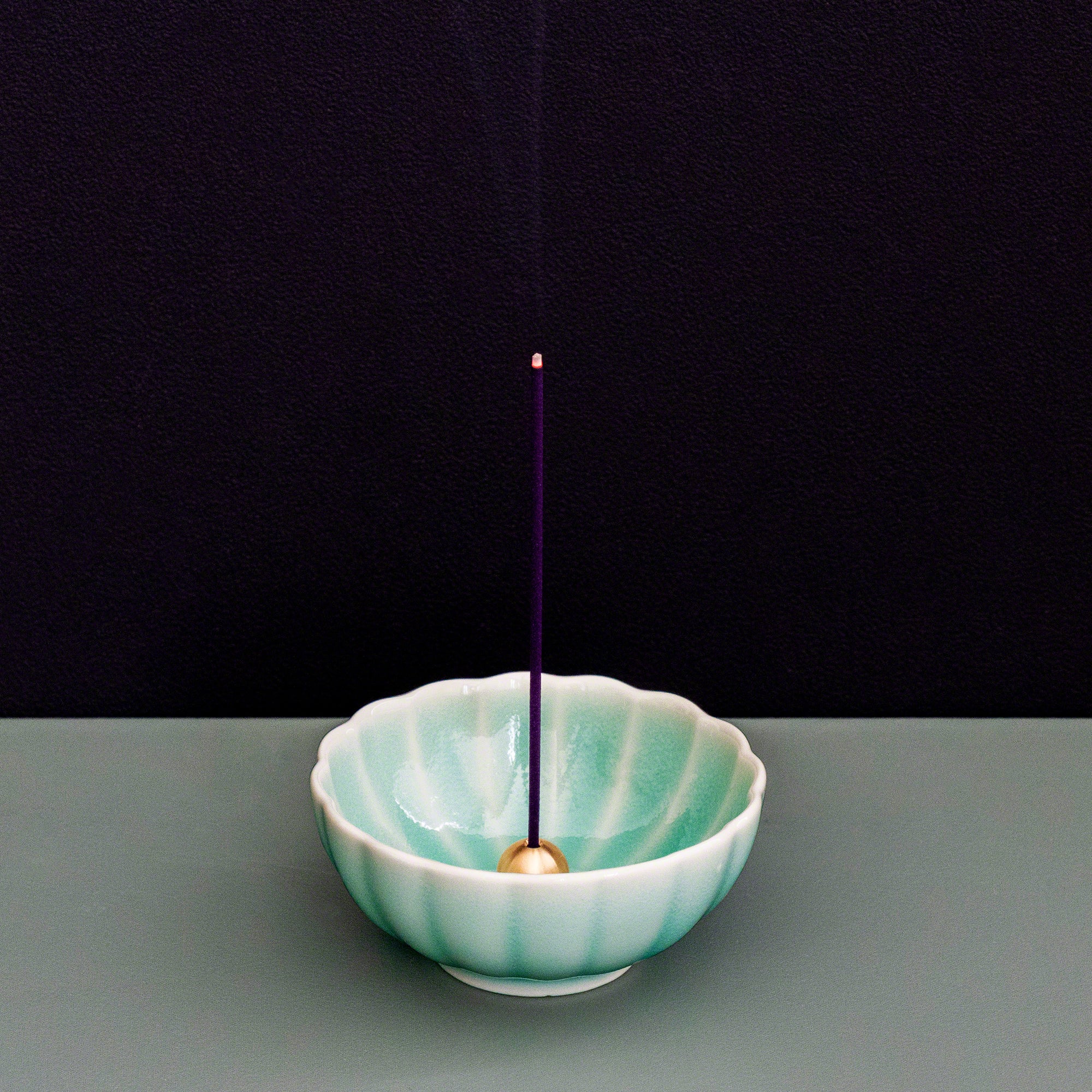 Sandalwood and rose incense sticks burning in an incense holder