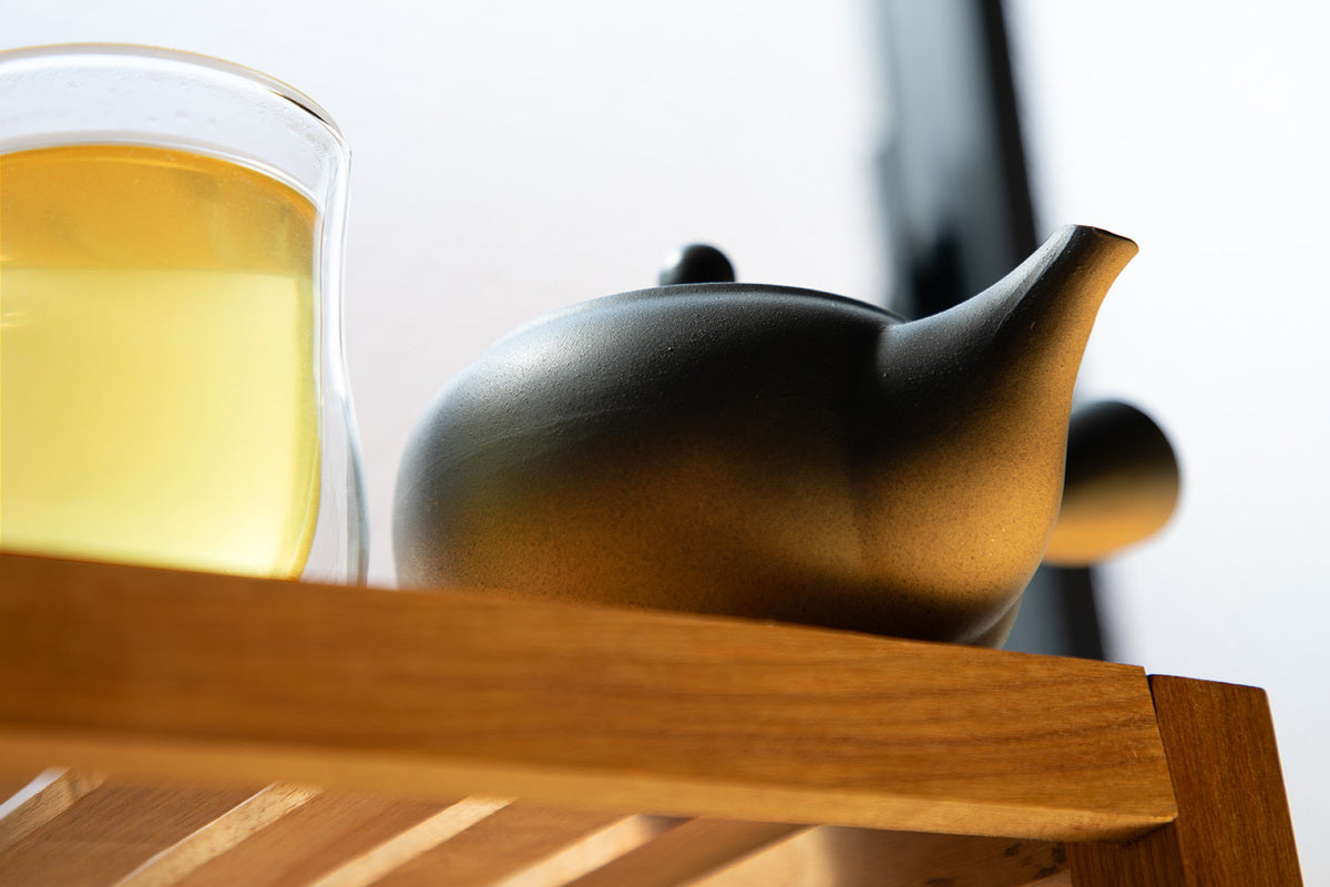 ceramic japanese tea pot with a glass of tea