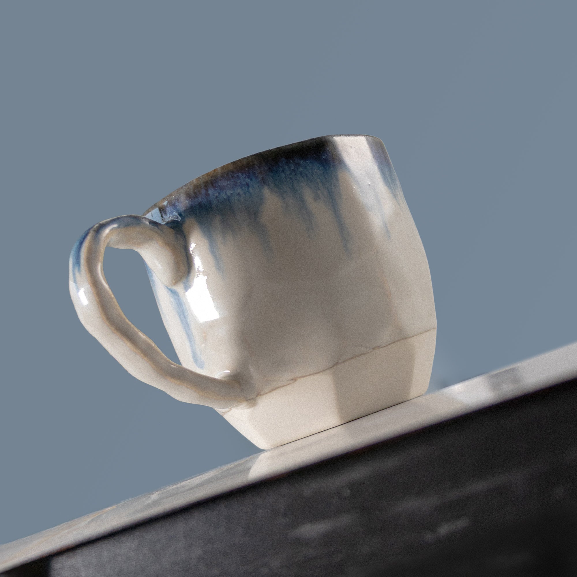 Blue and white cup on a support