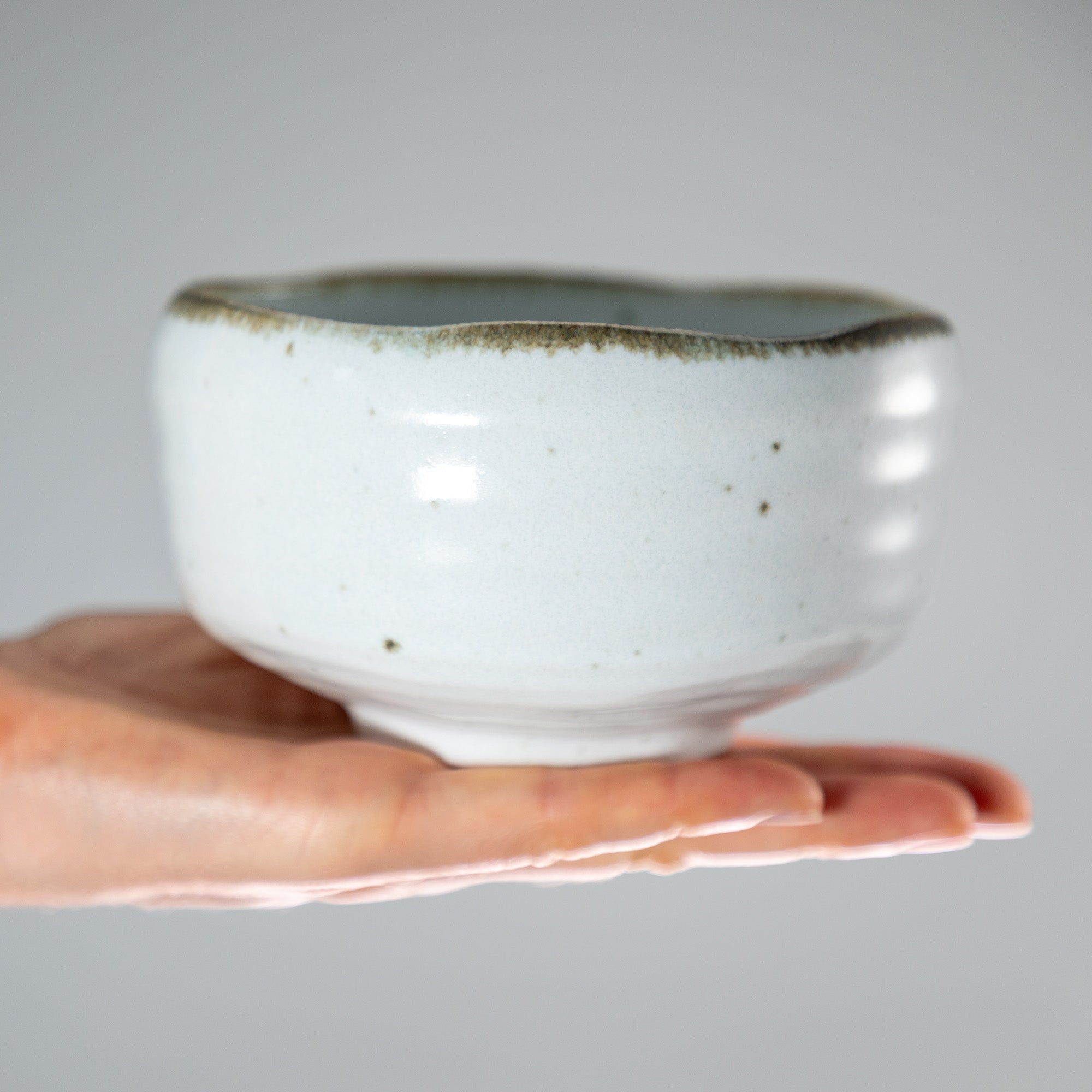 hand holding shirotsuchi white and brown Matcha Bowl