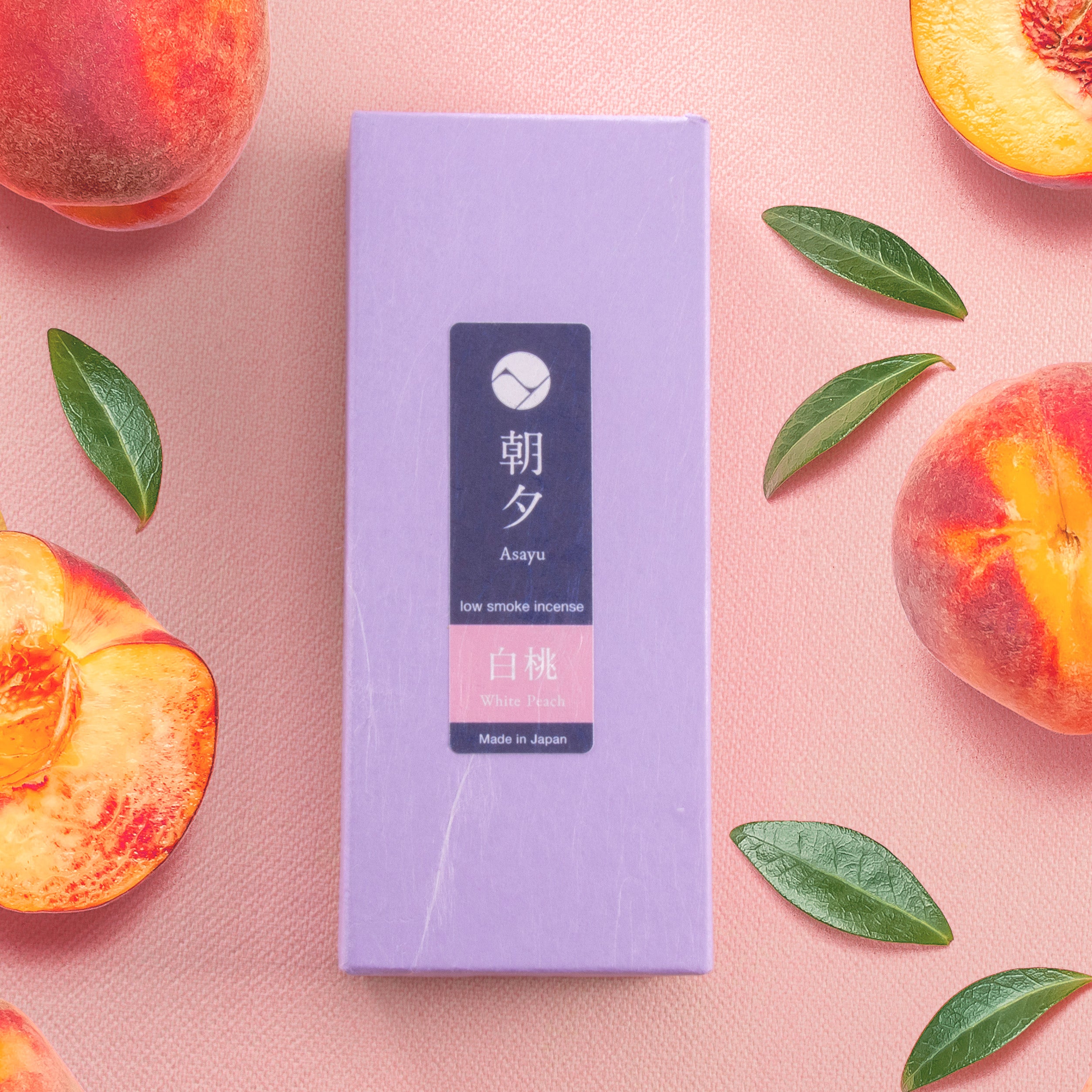 Peach incense sticks box next to peaches