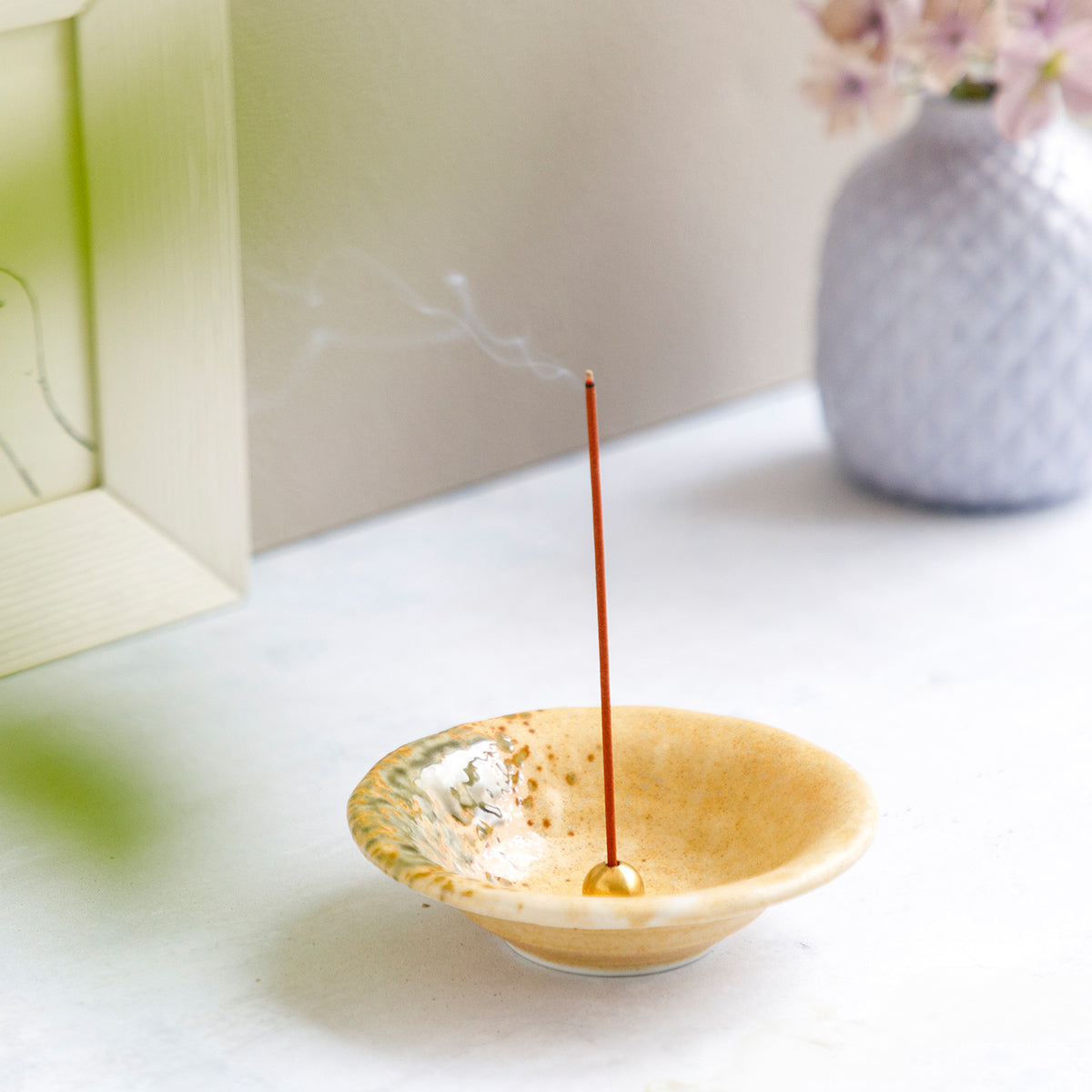 incense burning in ceramic orange holder