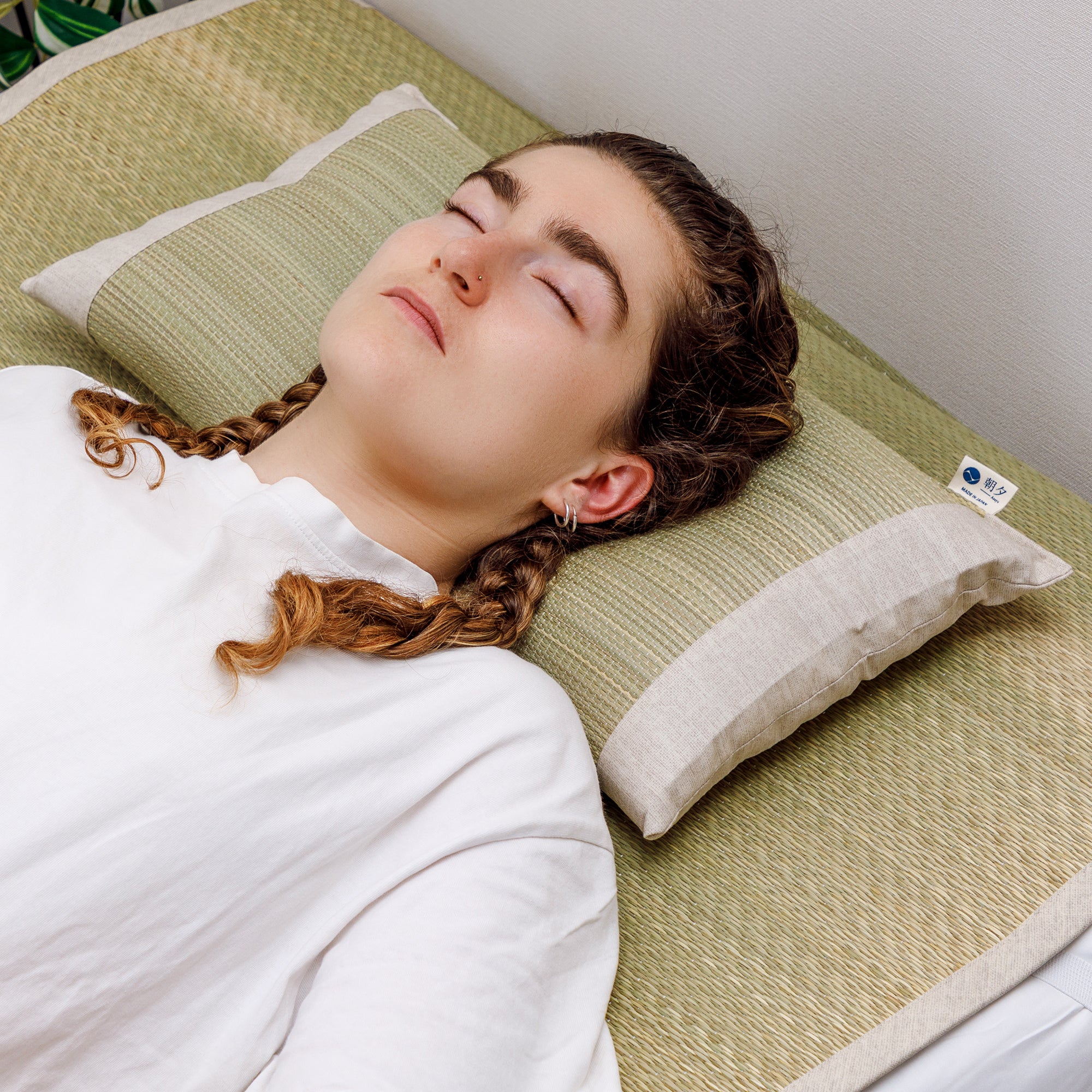 Someone sleeping on a Japanese Igusa Flat Pillow Beige