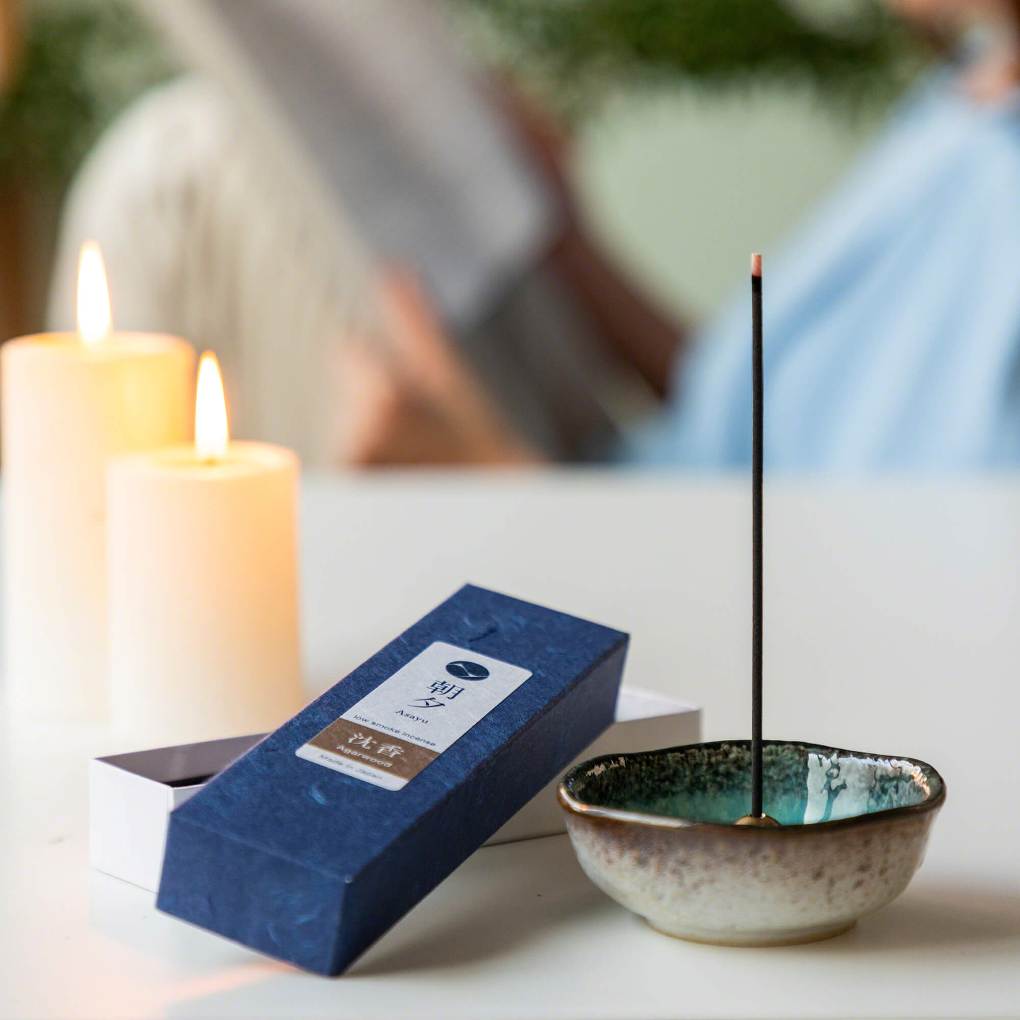 agarwood incense box next to small incense holder and candles