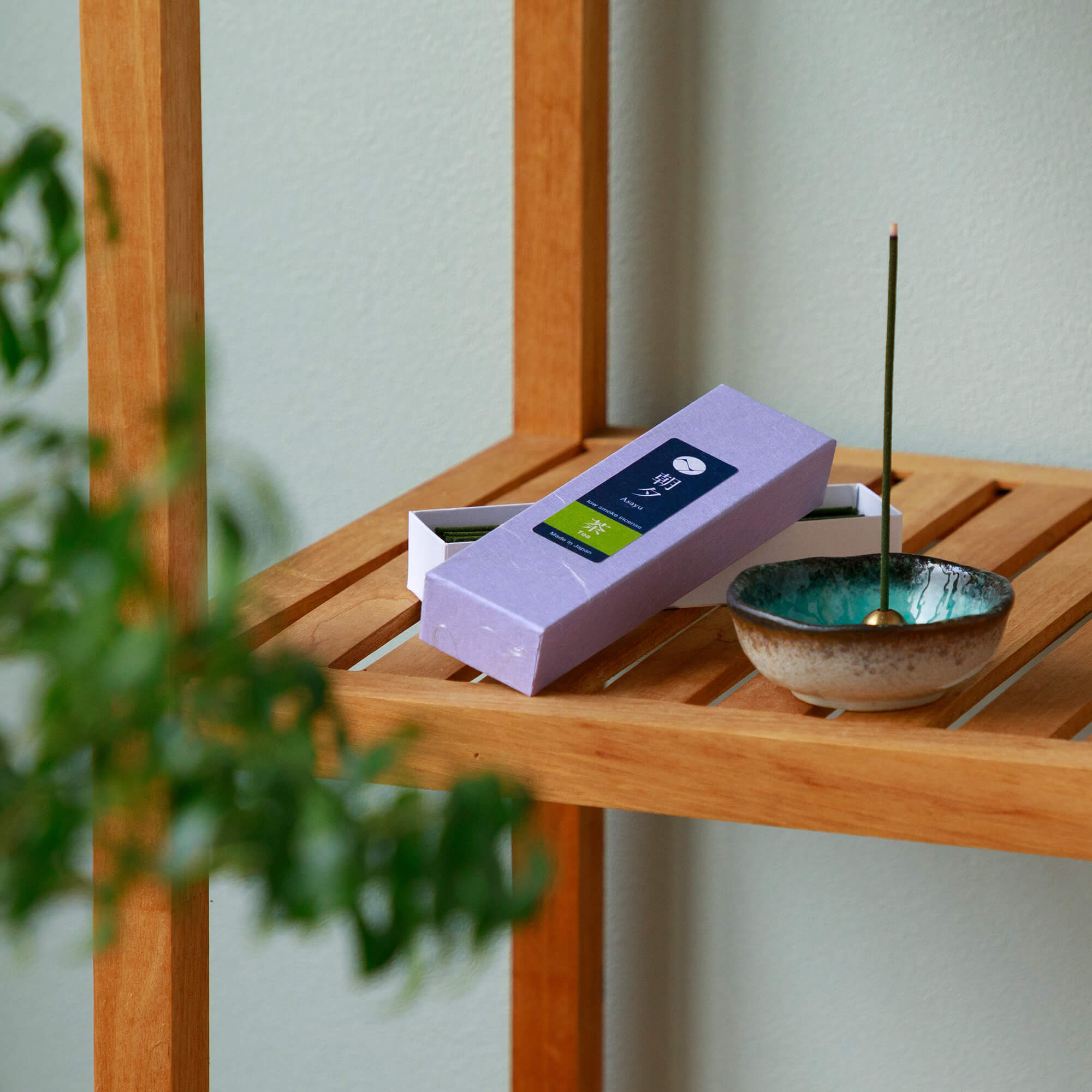 green tea incense with incense holder on wood shelf