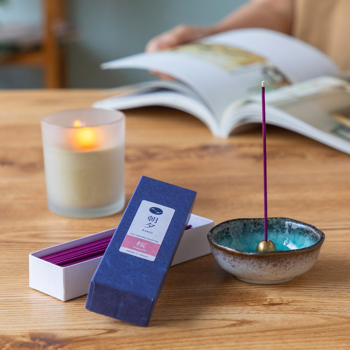 sakura incense sticks box with incense holder and a candle on a table
