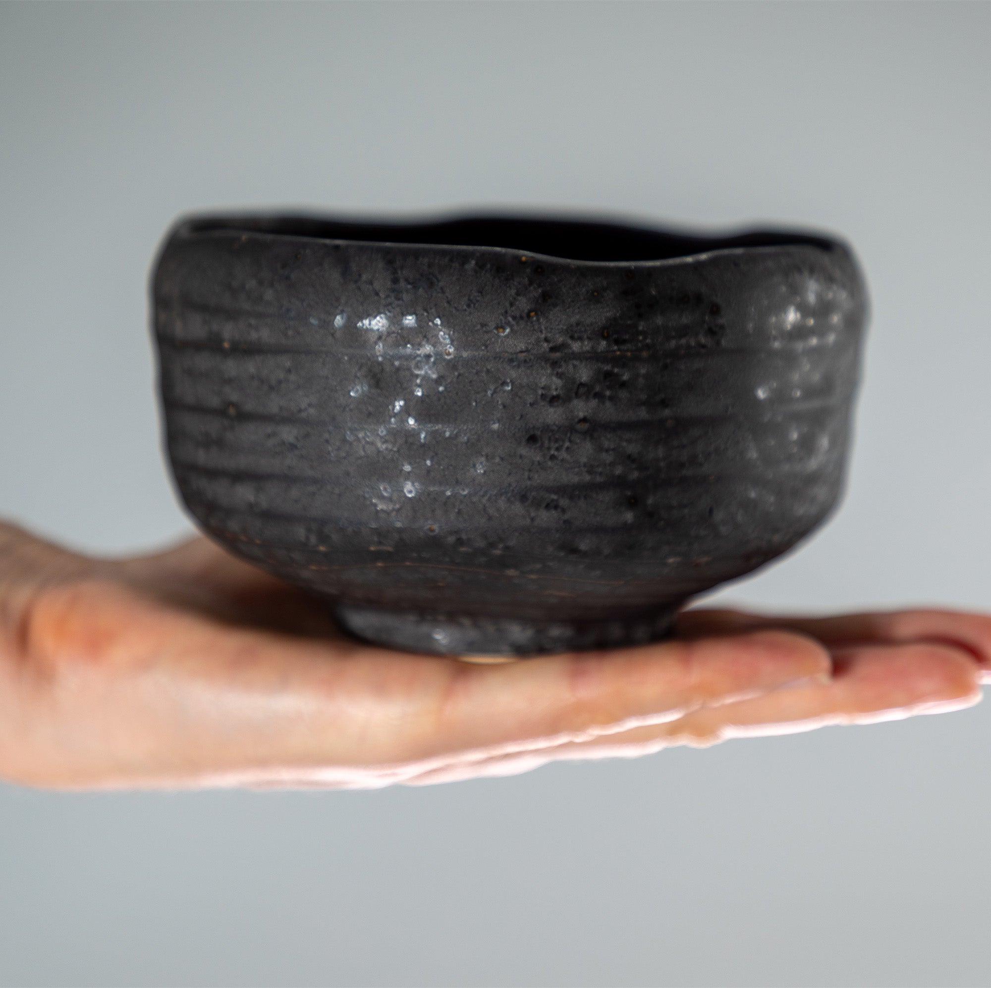 hand holding the Kurogane Black Matcha Bowl