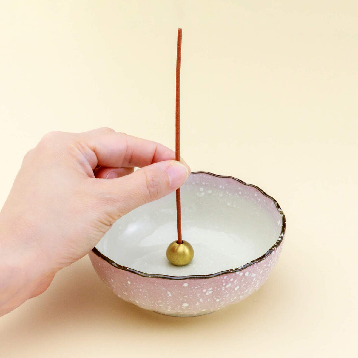 Pastel incense holder on yellow background