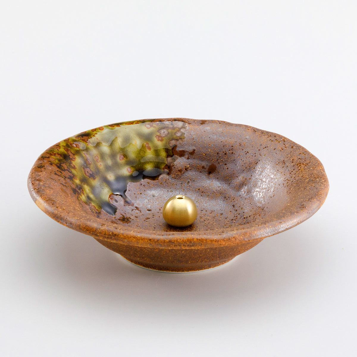 brass holder within the brown ceramic holder