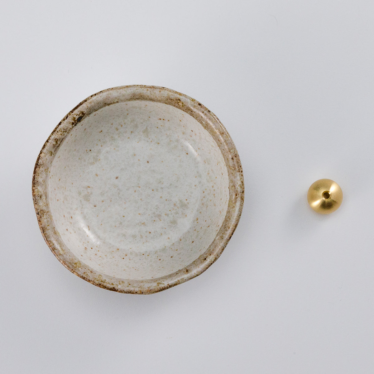 white ceramic incense holder with brass holder