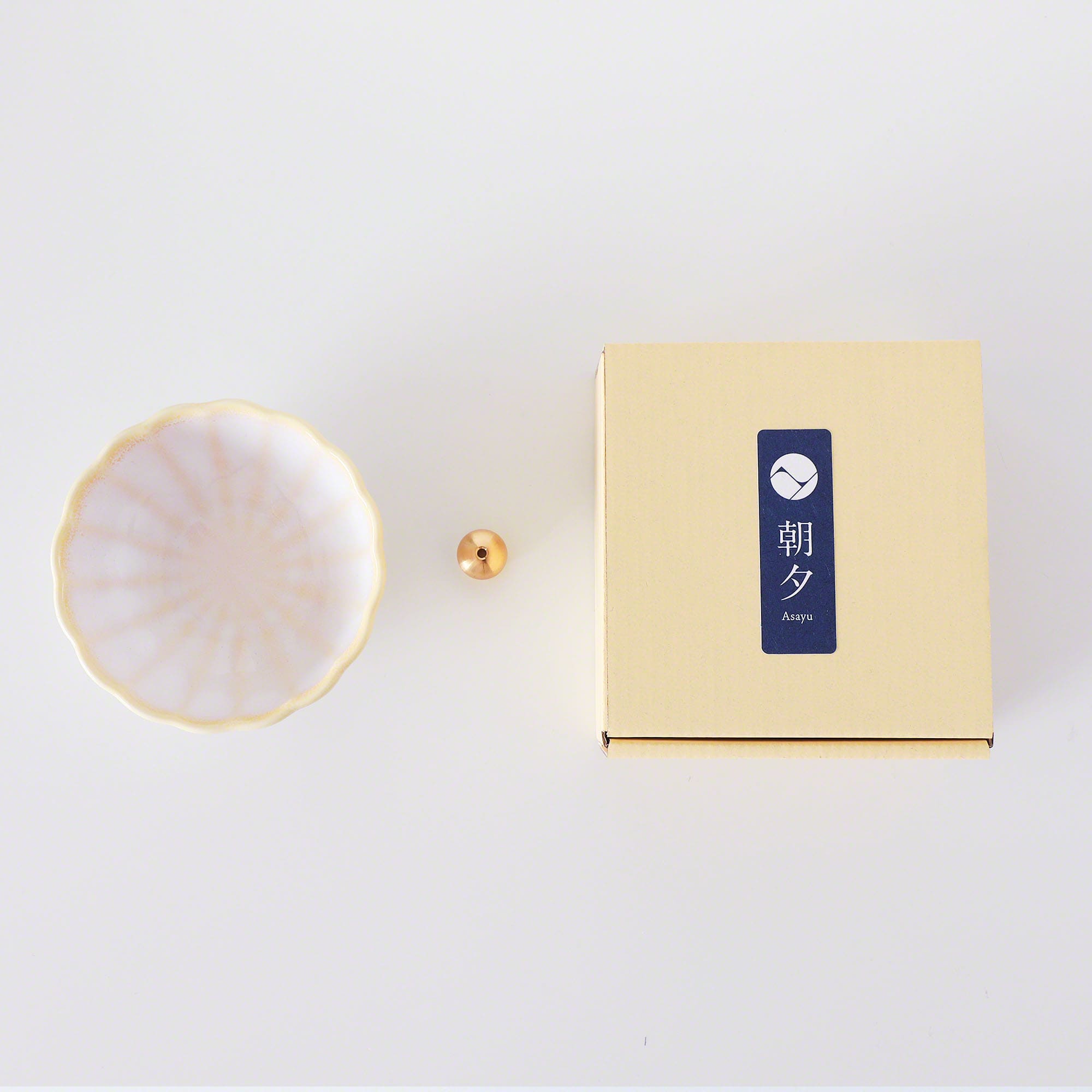 Asayu Japan White and Yellow Mini Lotus Flower Incense Plate next to the included brass incense stand and the packaging box.