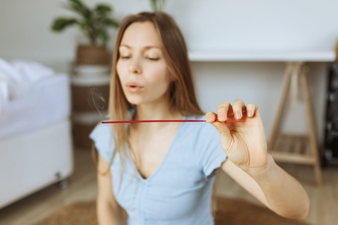 Women holding a burning incense stick