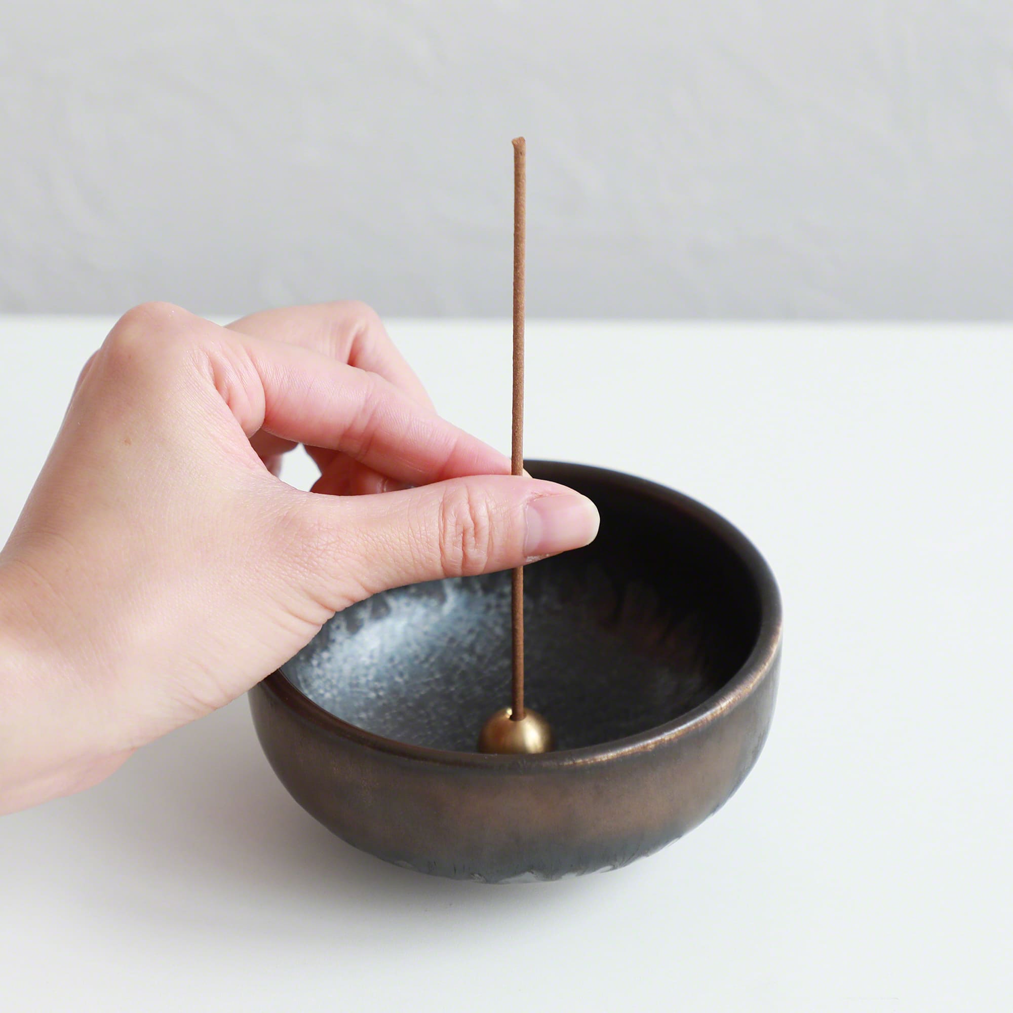 Put the frankincense stick in an incense stand over an incense plate or similar surface