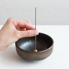 Put the patchouli incense stick in an incense stand over an incense plate or similar surface