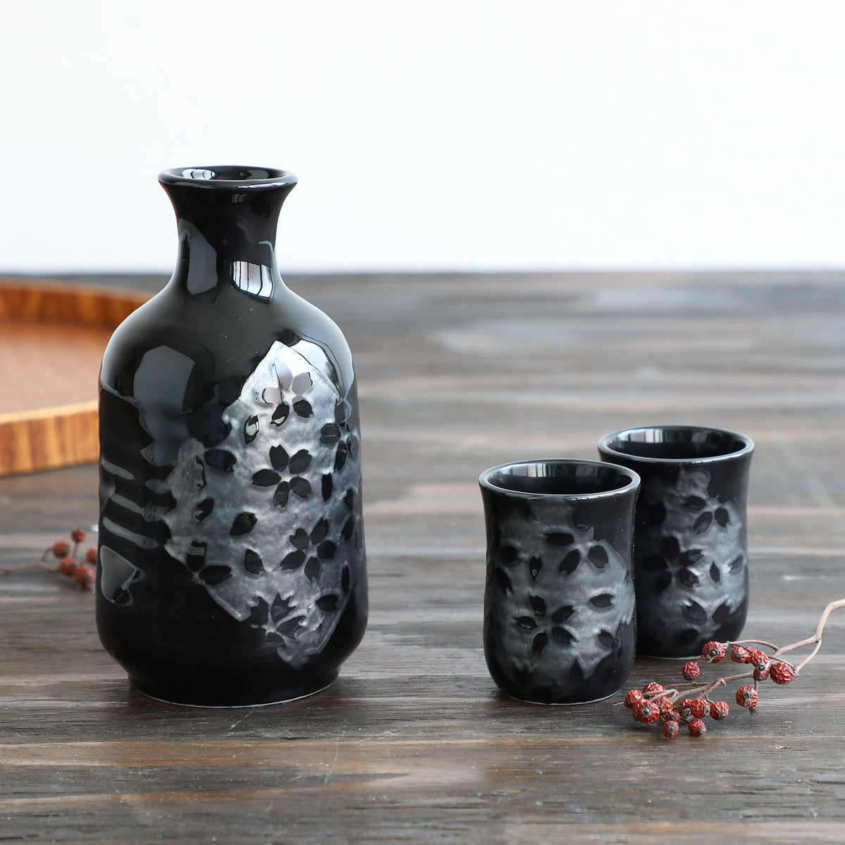 black sakura ceramic sake pitcher with two sake cups