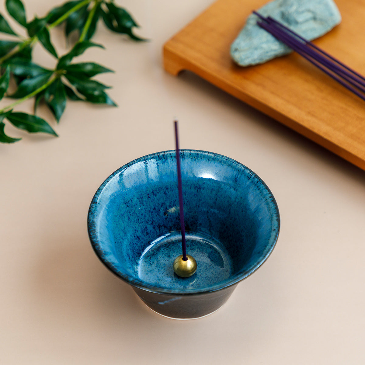 incense burning in cone shaped black and blue incense holder