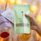 hand holding a pouch of genmaicha with matcha tea bags