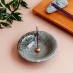 Incense burning in green ceramic holder