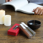 cinnamon and juniper incensebox with incenseholder and candales on a table