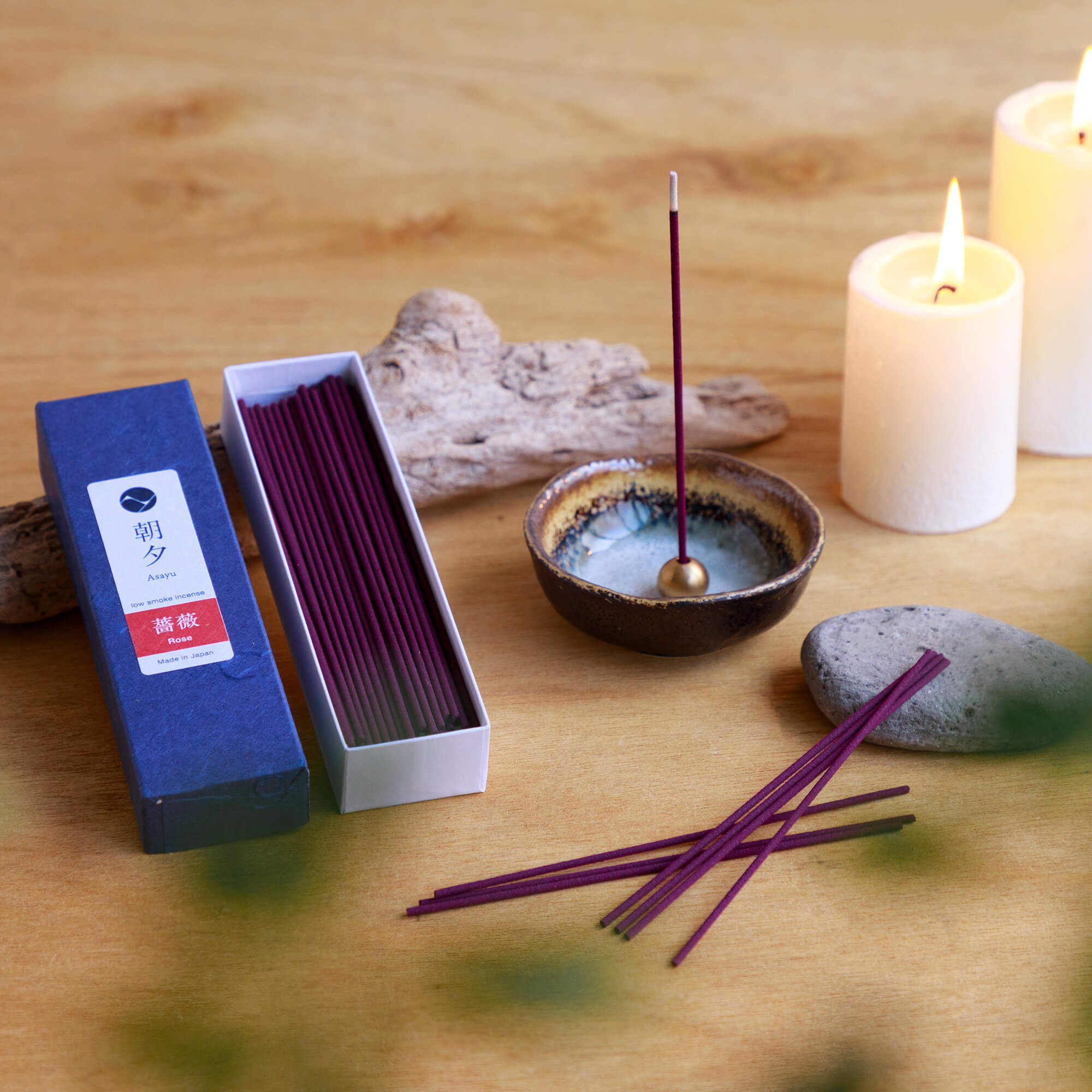 20g Box of rose incense sticks opened in display with incense holder and candles