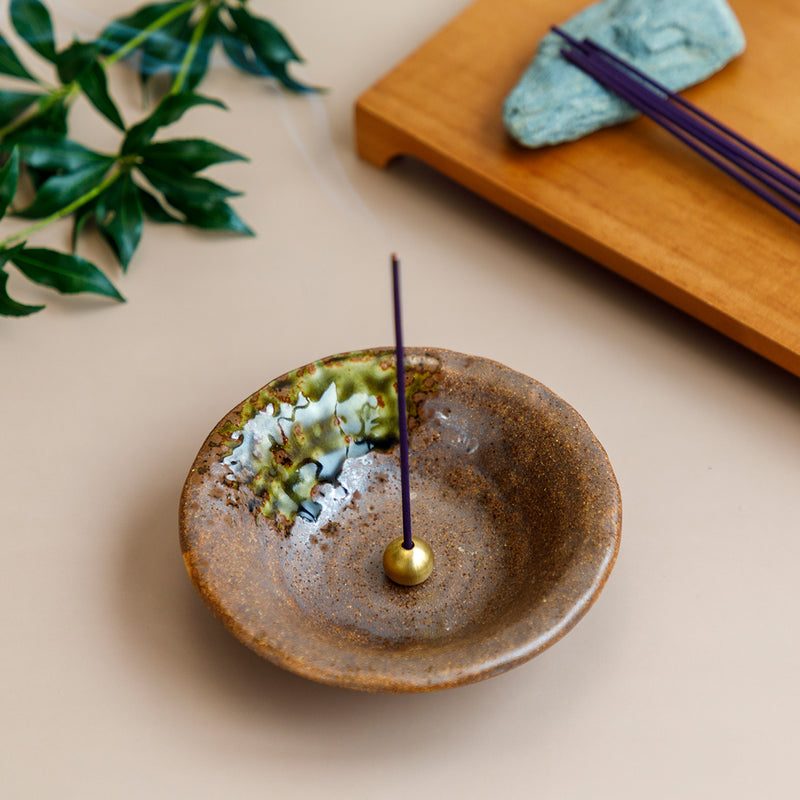 incense burning in ceramic brown holder