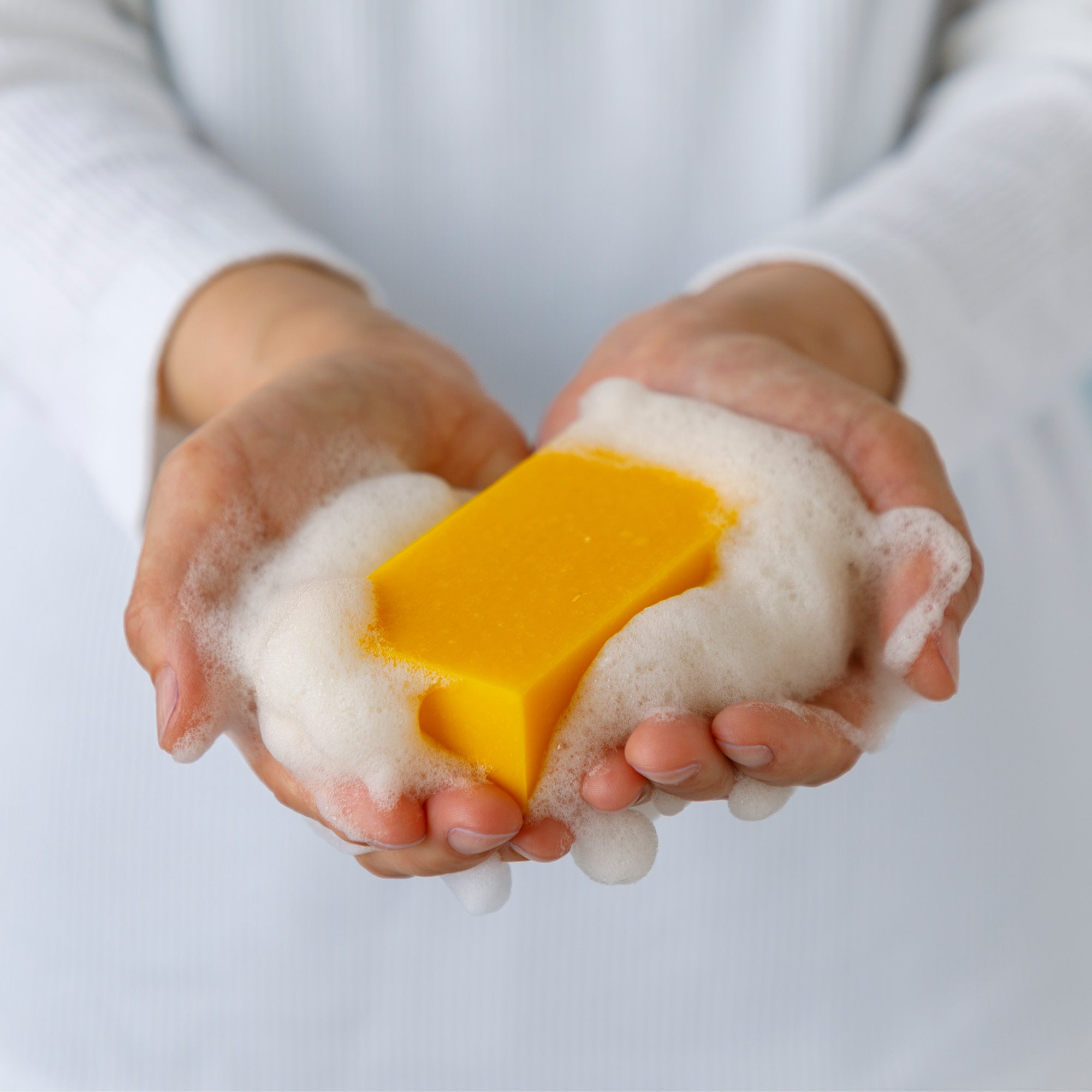 Hands holding a persimmon soap