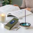 Sandalwood incense sticks variety pack with incense holder next to a candle