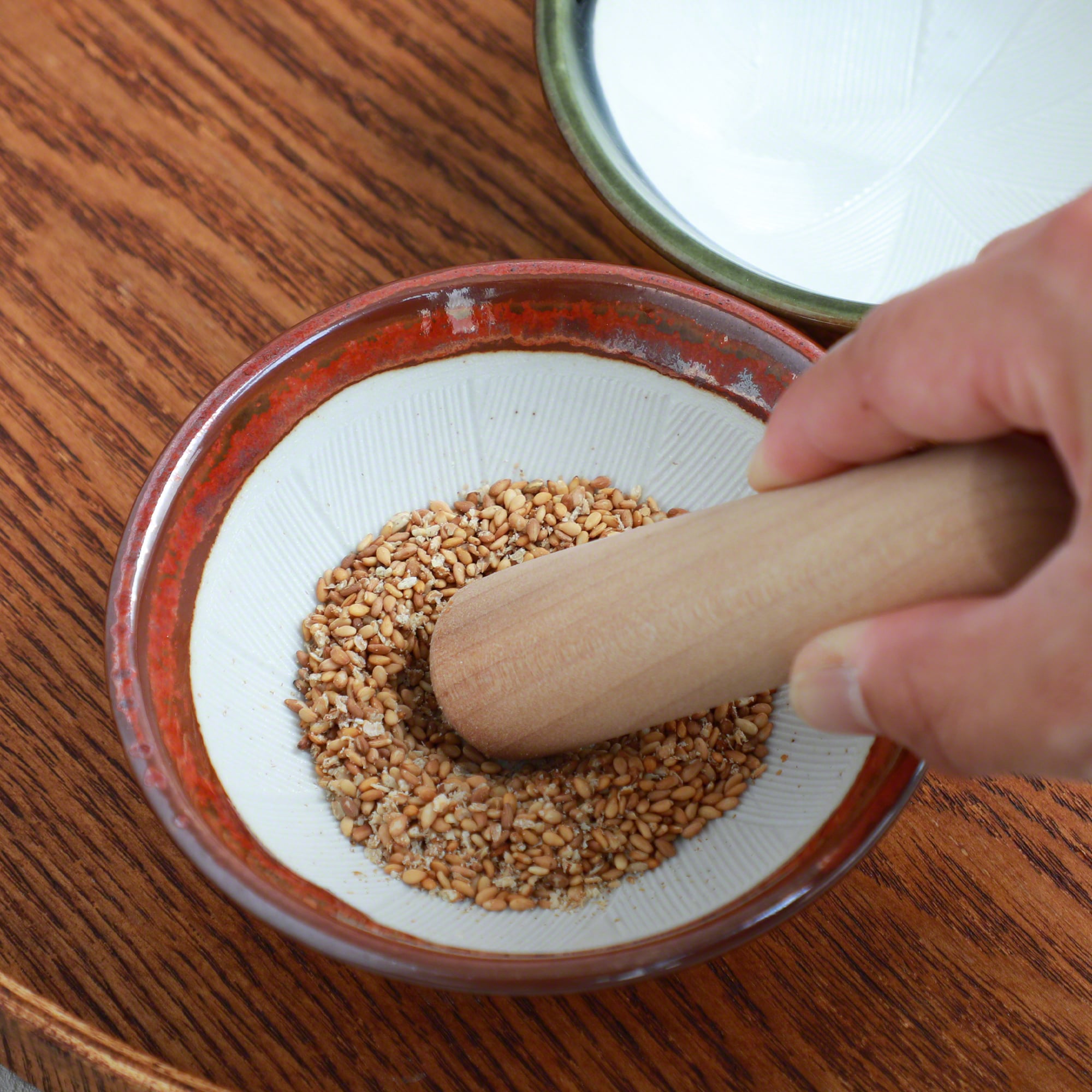 Grinding Sesame seeds with Asayu Japan Ceramid Red Mortar Bowl and Wooden Pestle.