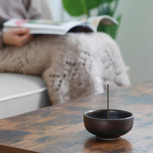 Charger l&#39;image dans la galerie, Asayu Japan Zen Incense Holder with burning incense Stick in a cozy living room with someone relaxing while reading a magazine
