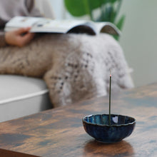 Load image into Gallery viewer, Asayu Japan Navy Blue Lotus Incense Holder with burning incense Stick in a cozy living room with someone relaxing while reading a magazine

