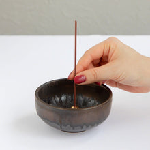 Load image into Gallery viewer, Put the sakura cherry blossom and sandalwood blend incense stick in an incense stand over an incense plate or similar surface
