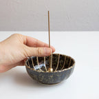 Put the incense stick in an incense stand over an incense plate or similar surface