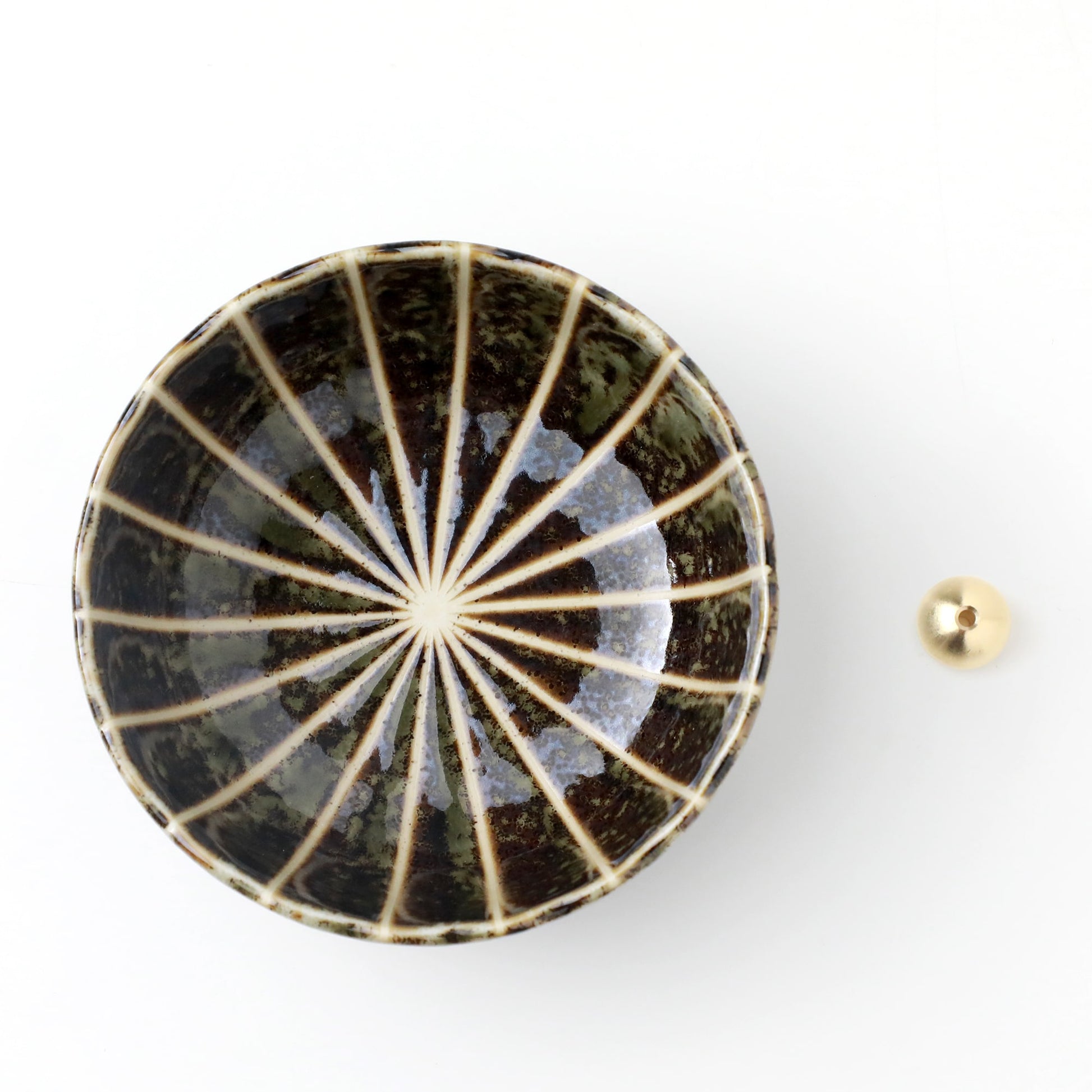 Asayu Japan dark green lotus flower ceramic incense plate with included brass incense burner stand next to it from the top.