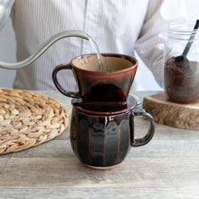 Load image into Gallery viewer, Pouring water over the paper filter on the mounted Asayu Japan Ceramic Coffee Dripper and Accessory Mug in chocolate brown to make coffee
