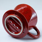 Bottom of the Asayu Japan Ceramic Coffee Dripper in chrome red with the 3 filter holes.