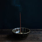 Sandalwood and Plum traditional incense sticks burning in an incense holder