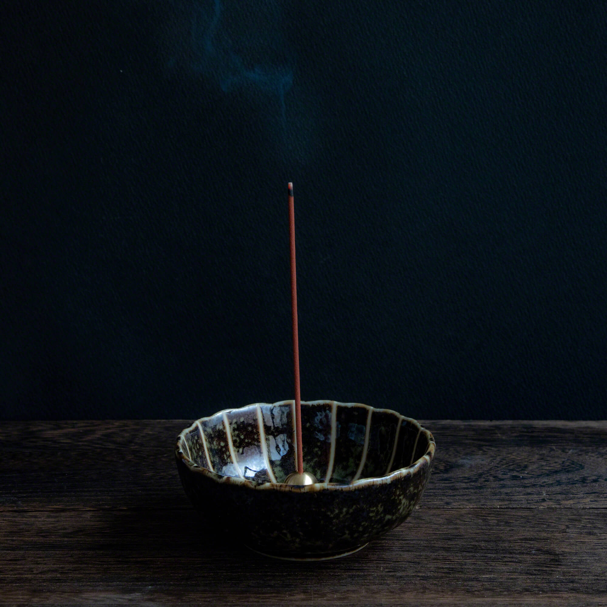 Sandalwood and Plum traditional incense sticks burning in an incense holder