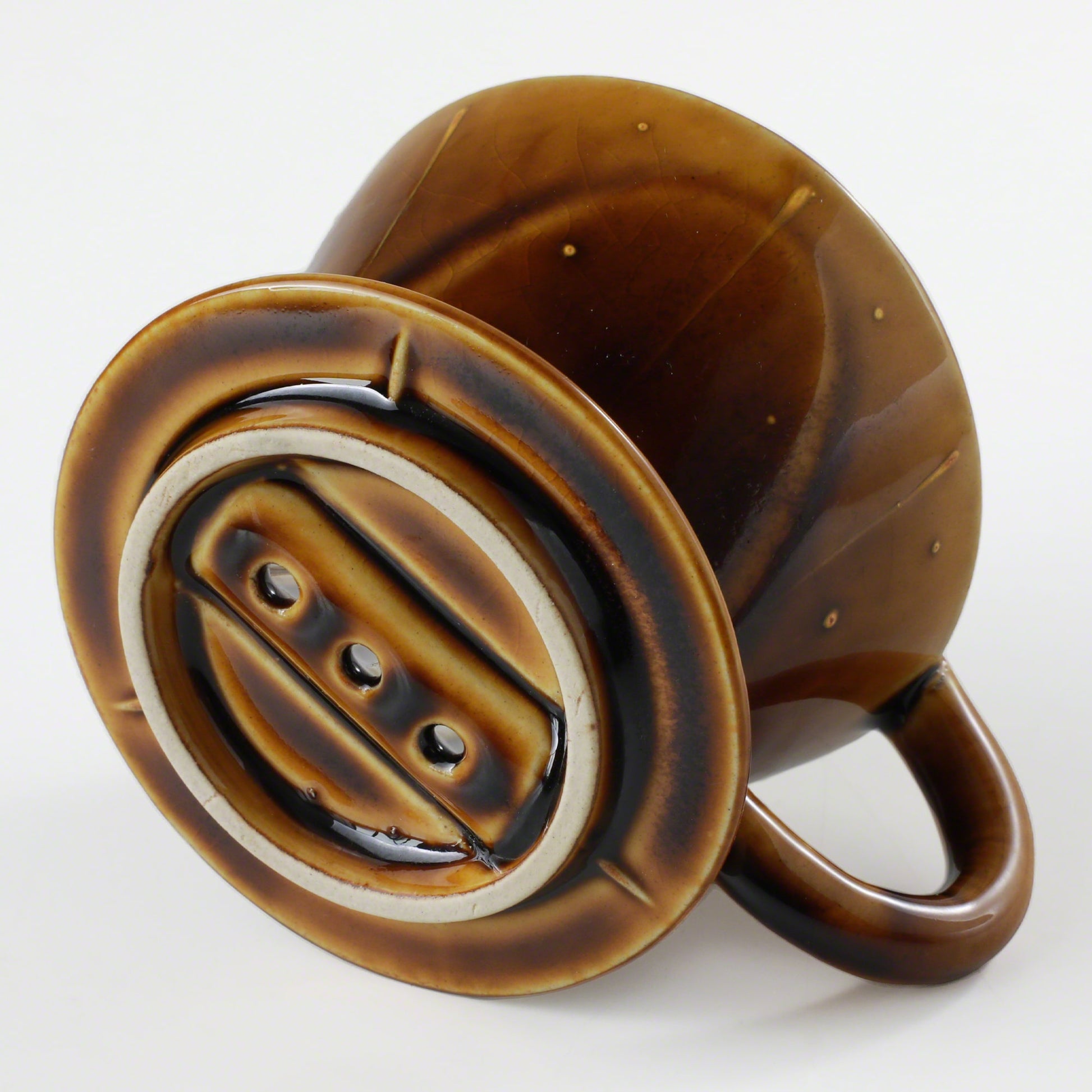 Bottom of the Asayu Japan Ceramic Coffee Dripper in Caramel with the 3 filter holes.