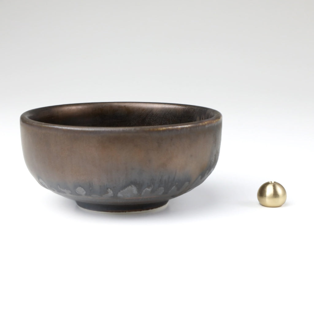 Asayu Japan Zen ceramic incense plate with included brass incense burner stand next to it from the side.