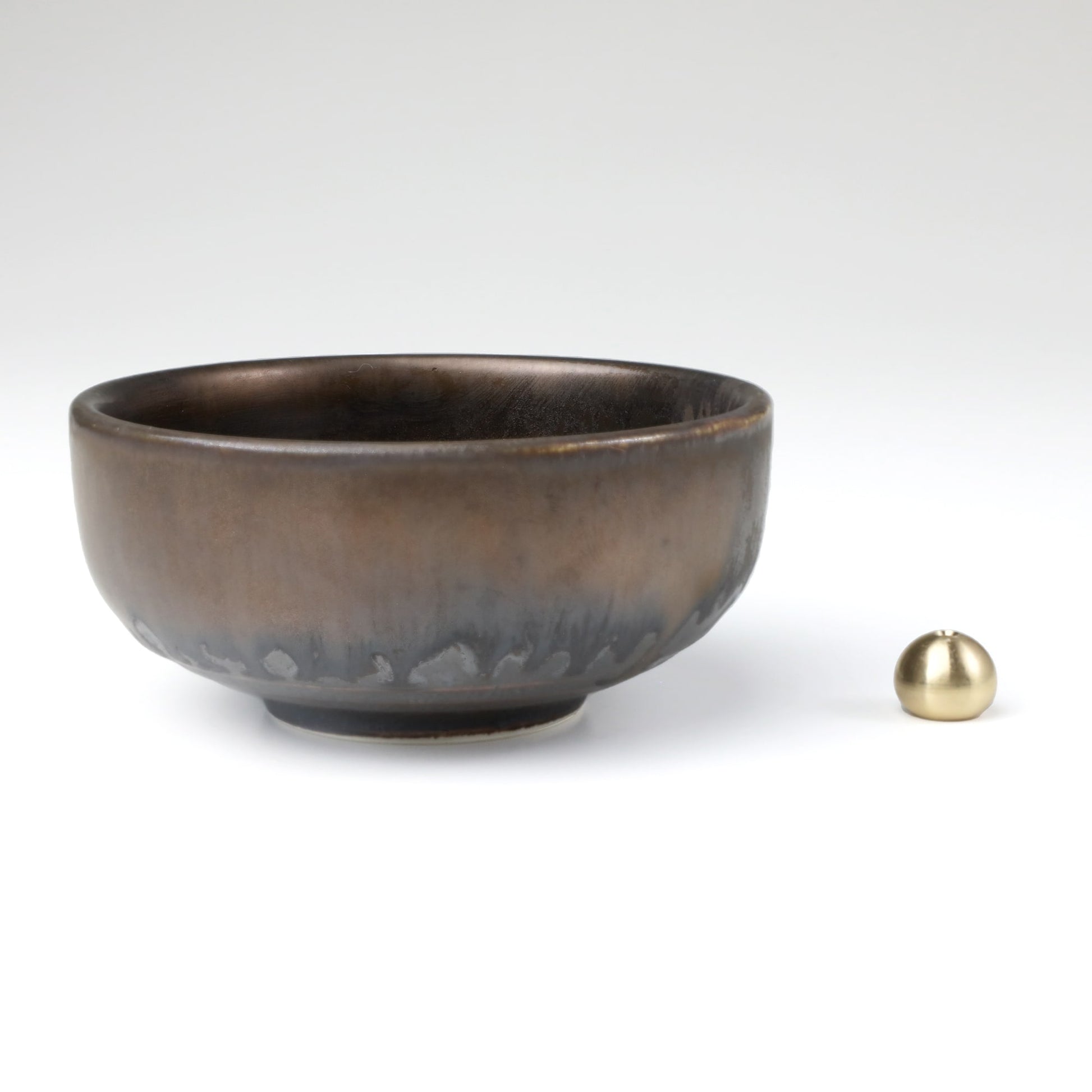 Asayu Japan Zen ceramic incense plate with included brass incense burner stand next to it from the side.