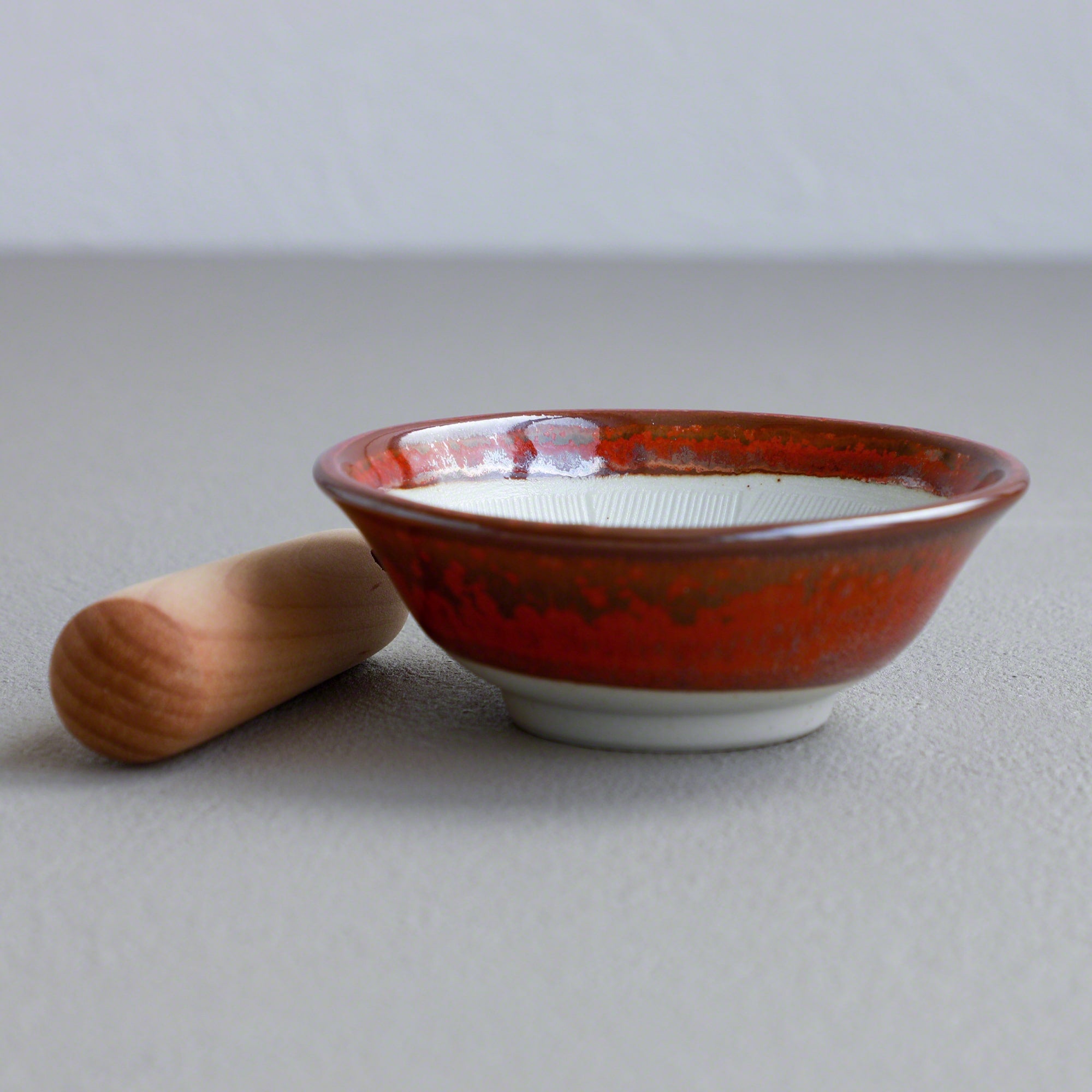 Asayu Japan Ceramic Red Mortar Bowl and Wooden Pestle seen from the side