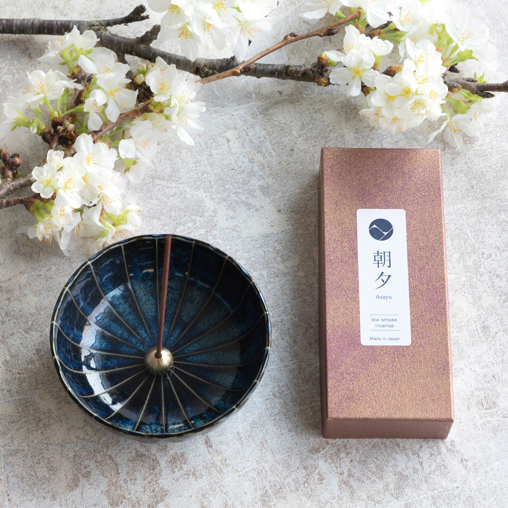 Asayu Japan Dark Navy Blue Lotus Incense Holder next to a Japan Incense Stick Set with Sakura and Green tea sticks and white sakura flowers.