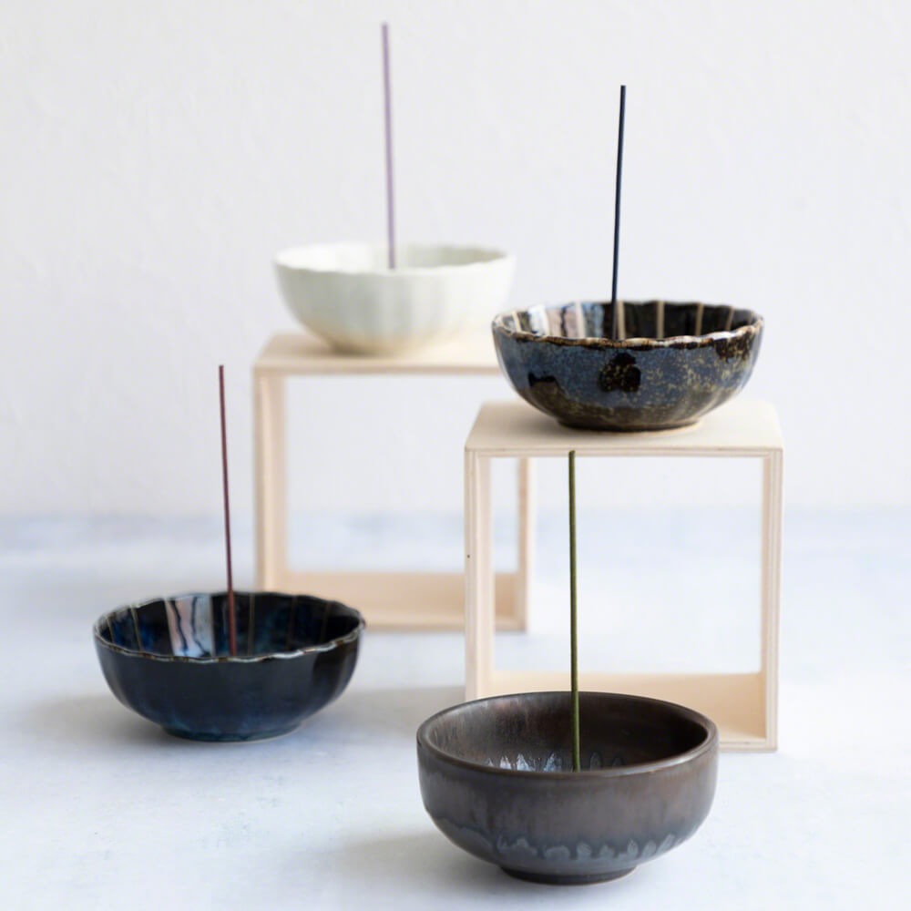 Four of Asayu Japan incense holders: Zen black and gold, dark navy blue lotus flower incense holder, white lotus flower incense holder and dark green lotus flower incense holder.