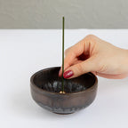 Put the lotus incense stick in an incense stand over an incense plate or similar surface