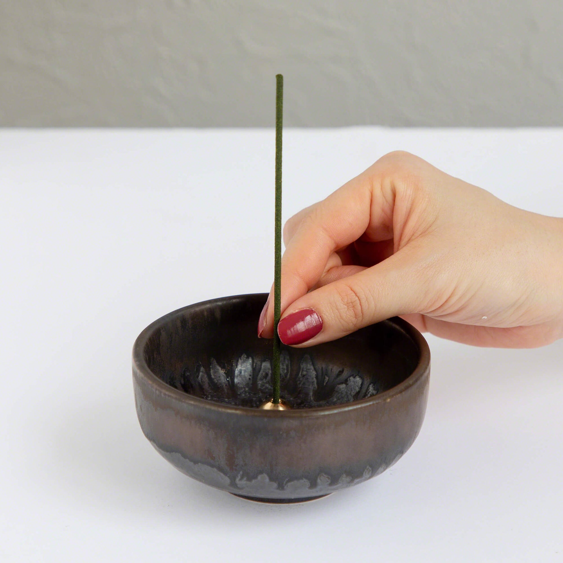 Put the lotus incense stick in an incense stand over an incense plate or similar surface