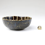 Asayu Japan dark green lotus flower ceramic incense plate with included brass incense burner stand next to it from the side.