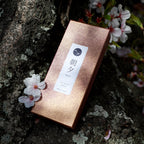 Premium Sakura Incense box display on a cherry blossom tree trunk